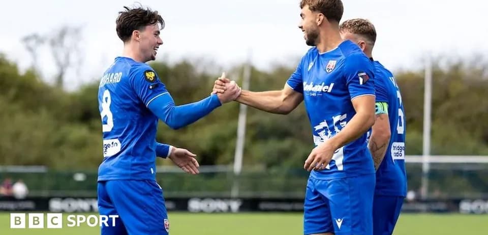 Two players celebrating a goal with handshake