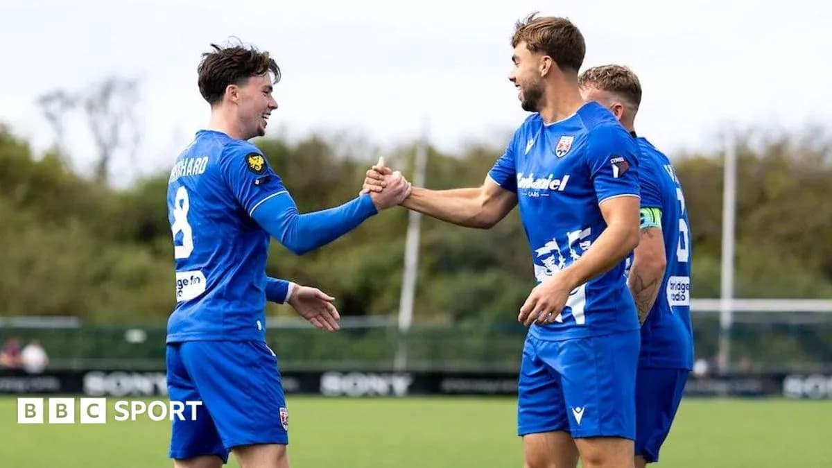Two players celebrating a goal with handshake