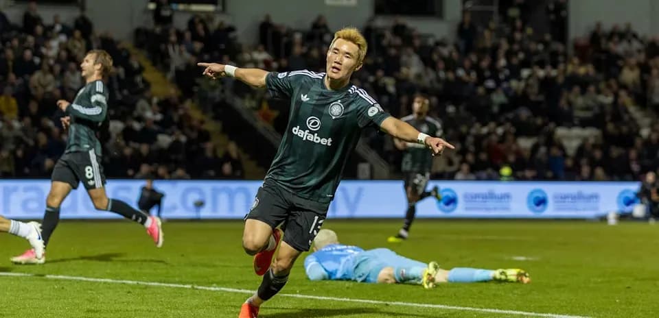 Player celebrating goal with teammates in background