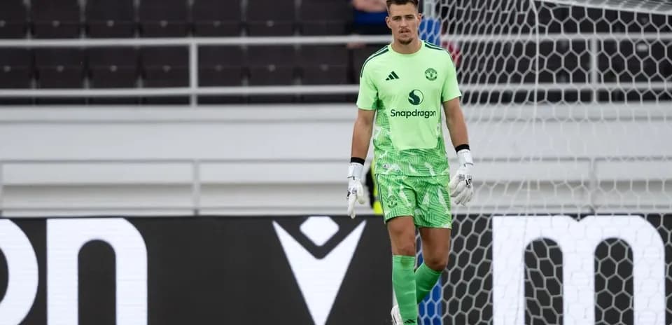 Goalkeeper in green kit standing by goalpost
