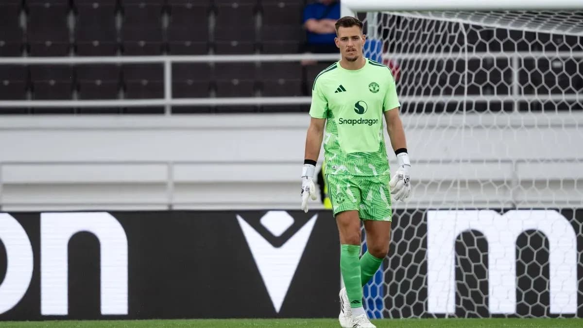 Goalkeeper in green kit standing by goalpost