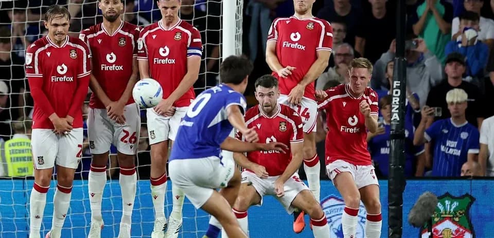 Player taking free kick against wall of defenders