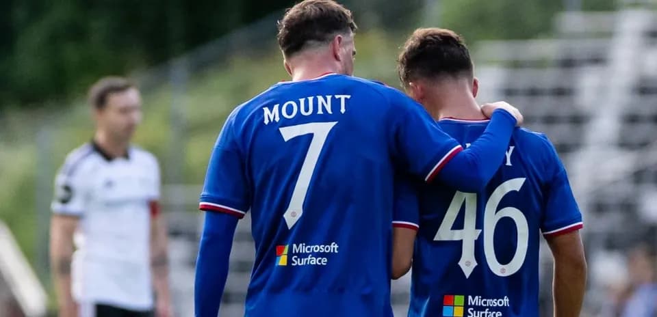 Two players in blue jerseys during match conversation