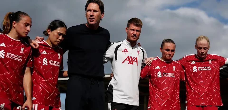 Liverpool women's team huddling with coaching staff