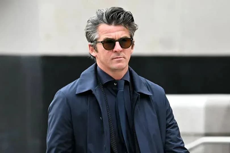 Man in sunglasses wearing a dark coat outdoors