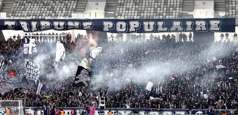 Crowd of fans with banners and smoke at stadium