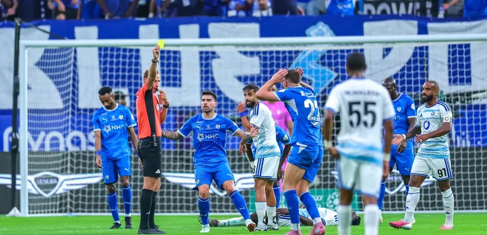 Referee shows yellow card during football match