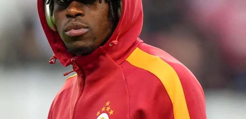 Player in red and yellow Galatasaray hoodie on sidelines