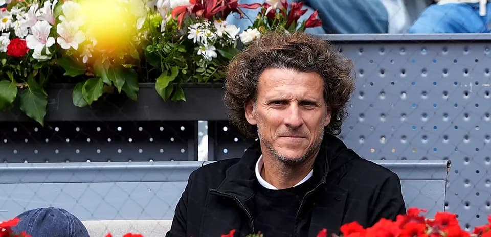 Man seated in front of flower arrangement at event