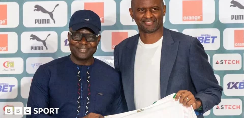 Two men holding a football shirt at press event