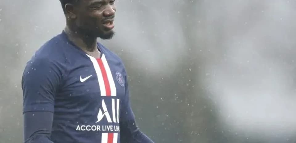 Player training in rain wearing PSG kit