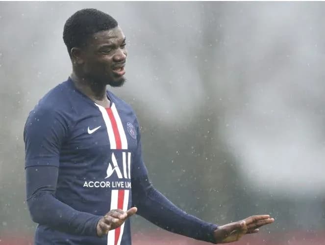 Player training in rain wearing PSG kit