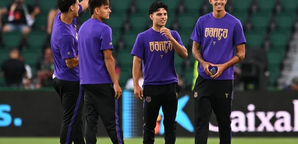 Players warming up on field in purple jerseys