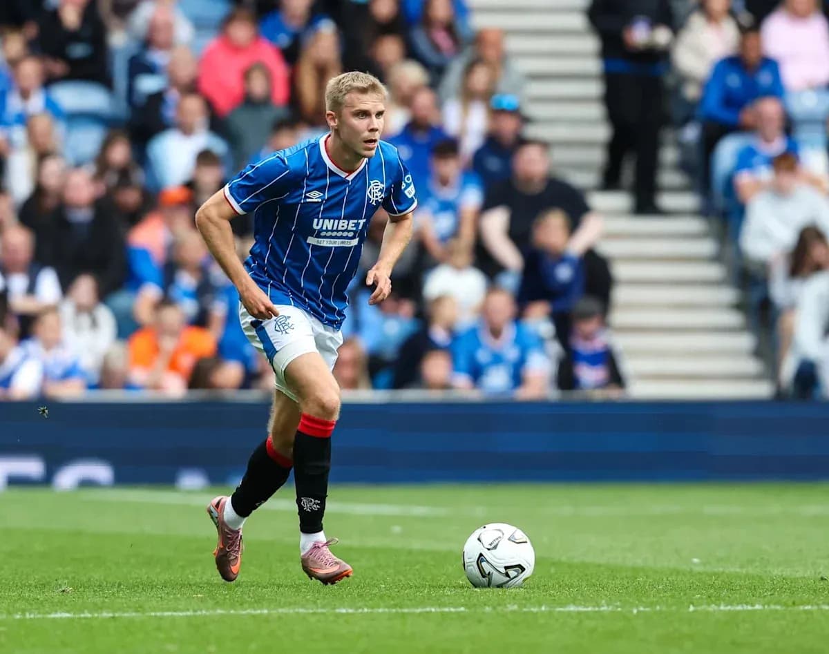 Player in blue kit running towards soccer ball
