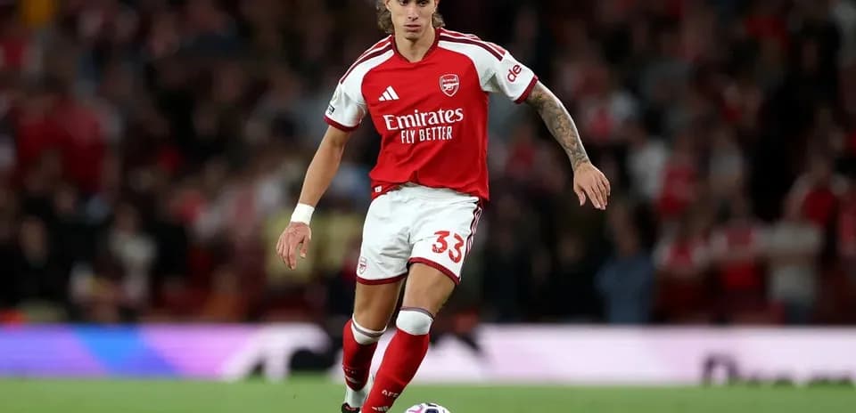 Arsenal player running with the ball on field