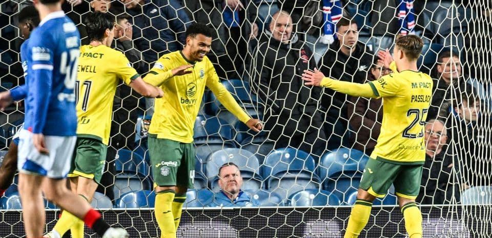 Players celebrating a goal in front of the net
