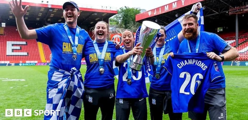 Birmingham City players celebrating with trophy on field