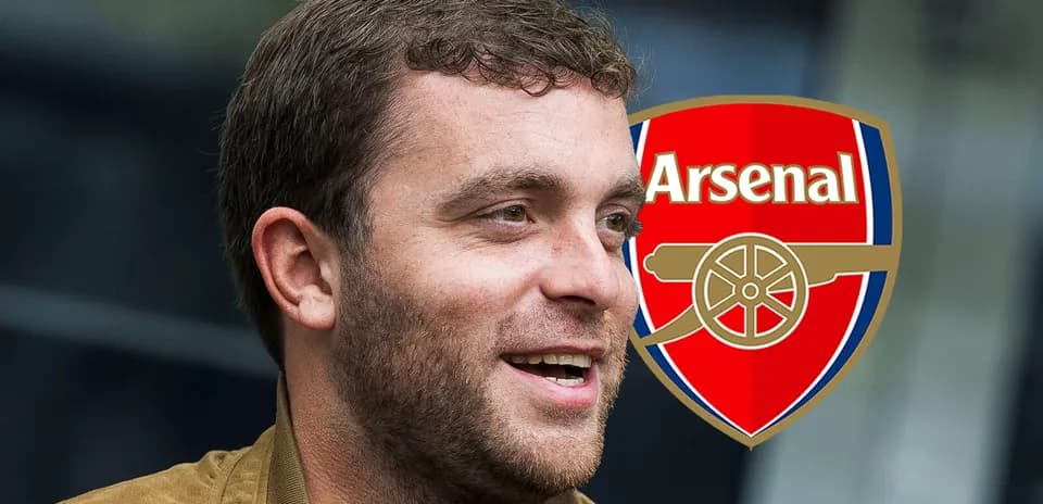 Man smiling with Arsenal logo in background