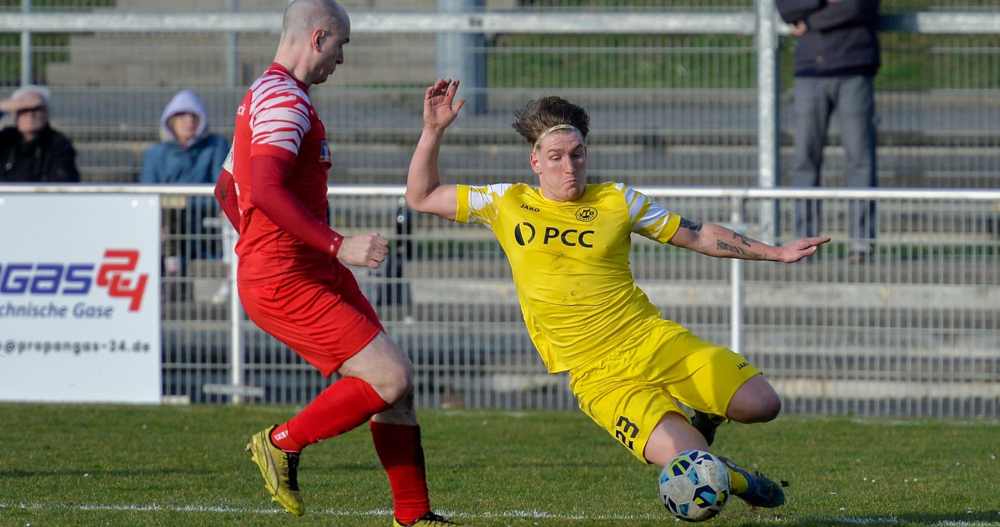 Player sliding tackle during Büderich vs SF Baumberg match