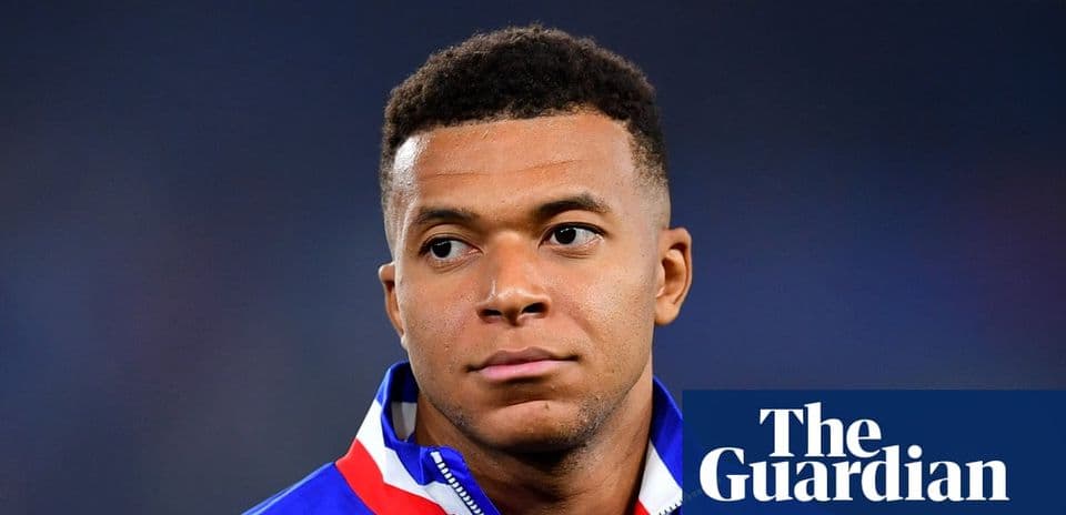 Football player wearing team jacket, looking serious