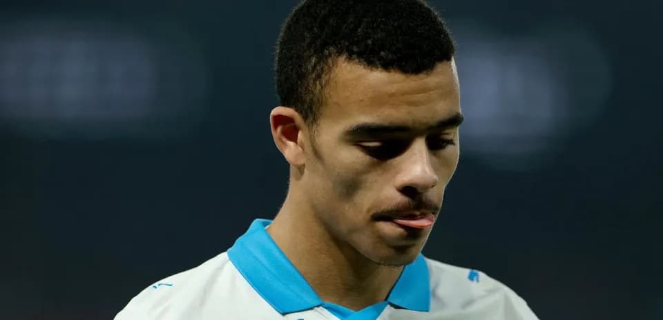 Player in white jersey looking down with focused expression
