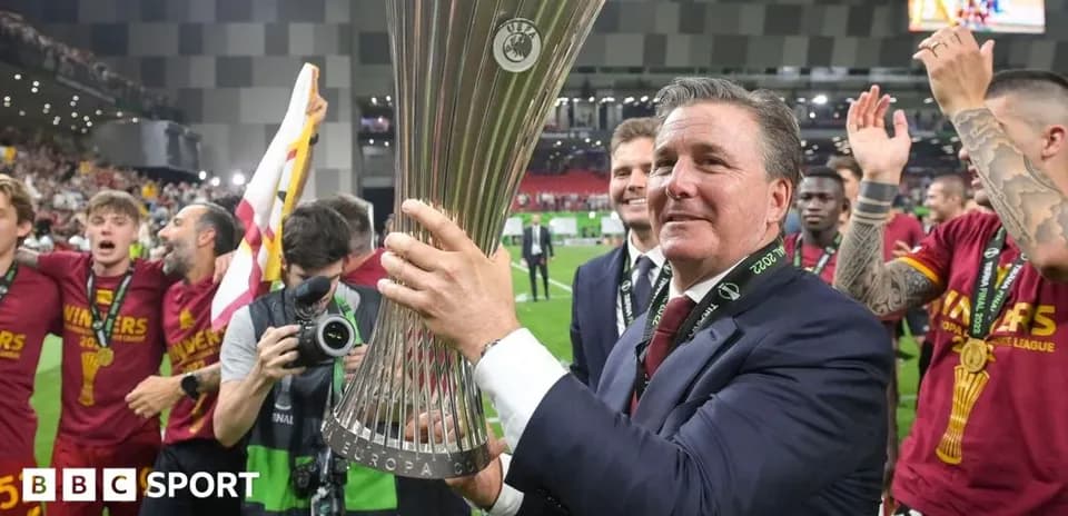 Coach celebrating with UEFA Europa League trophy