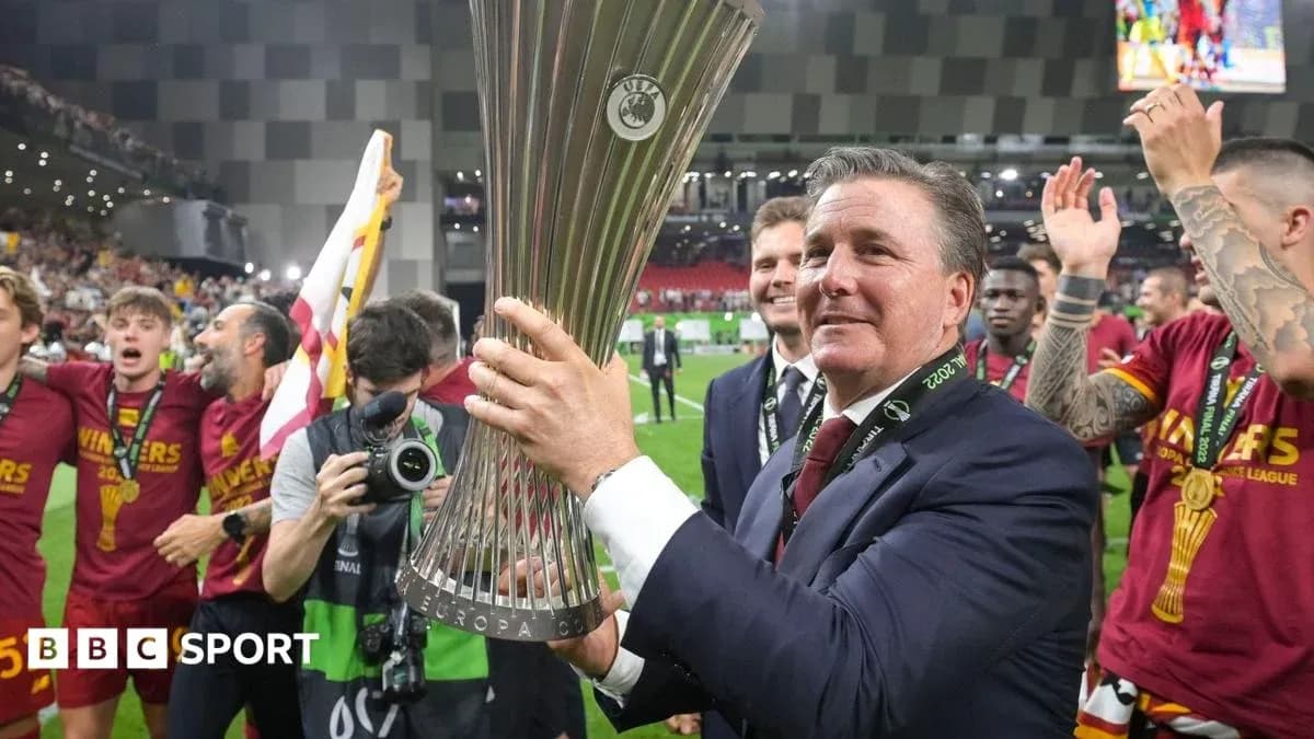 Coach celebrating with UEFA Europa League trophy