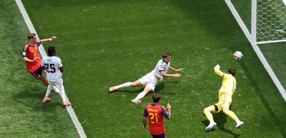 Player attempting to score as goalkeeper stretches