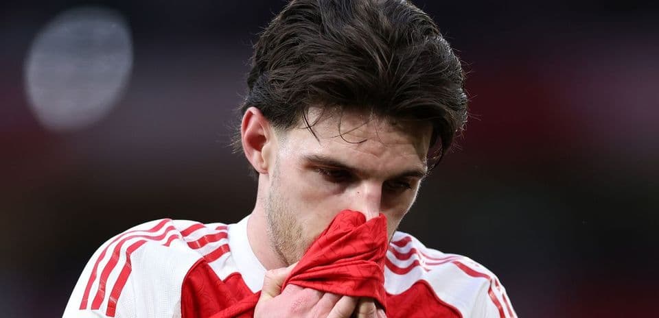 Player looking down while holding jersey to face