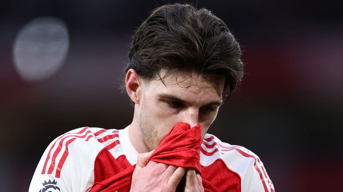 Player looking down while holding jersey to face
