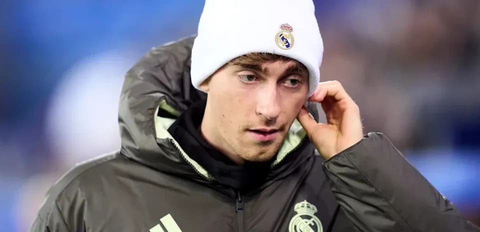 Player in Real Madrid jacket and beanie during match