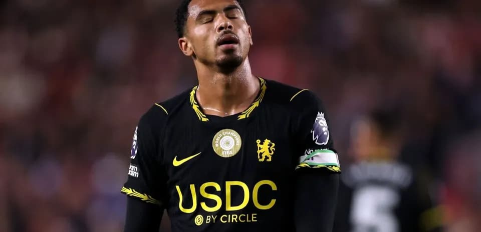 Player in black jersey looking dejected on field