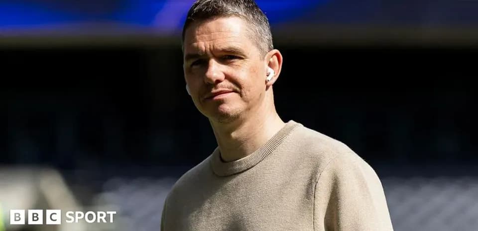 Person wearing earbuds, standing in stadium