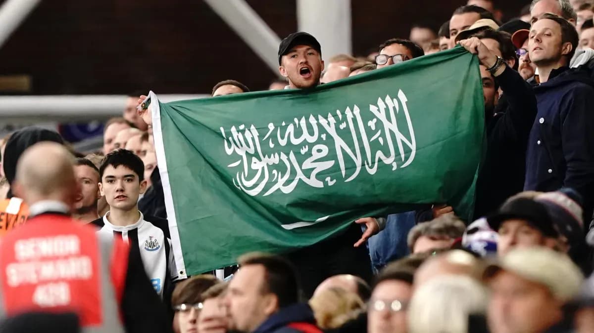 Fan holding Saudi Arabian flag in the crowd