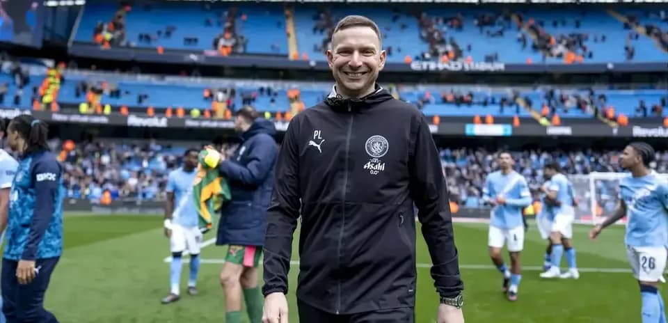 Assistant coach walking off the pitch after match
