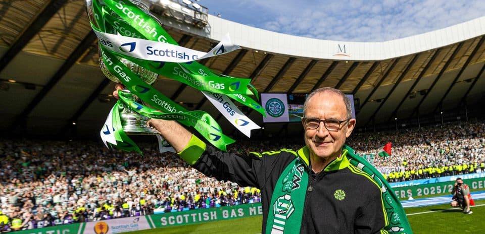 Man celebrating with trophy and Celtic scarf