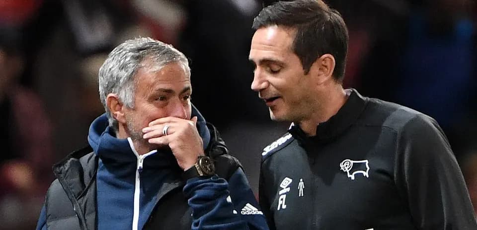 Two coaches conversing on the sidelines during match