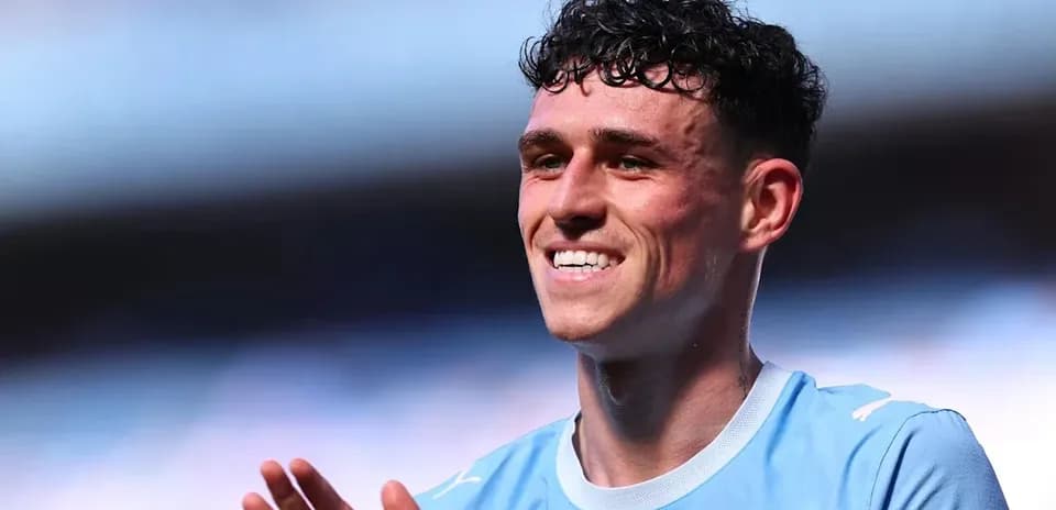 Player in light blue jersey smiling and applauding
