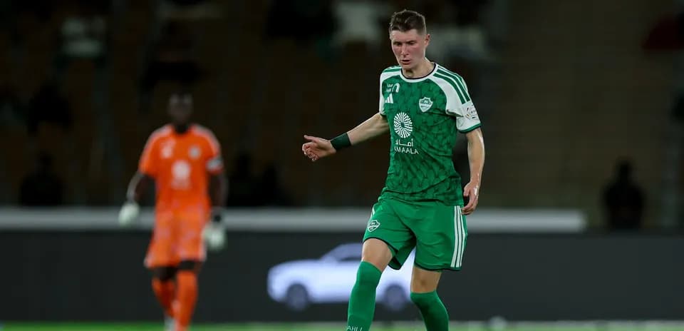 Player in green kit dribbling ball during match
