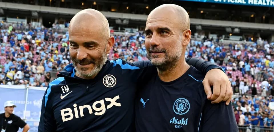 Two coaches smiling together after a match