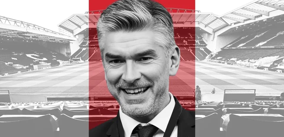 Man smiling in front of football stadium
