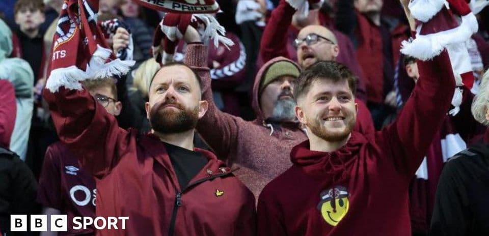 Fans celebrating and waving scarves in stadium