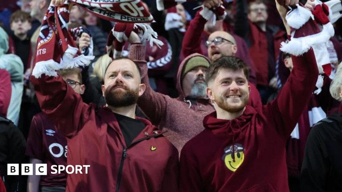 Fans celebrating and waving scarves in stadium