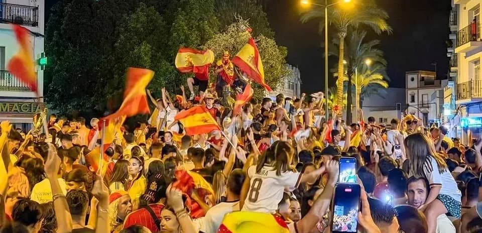 Crowd celebrating with flags in nighttime street