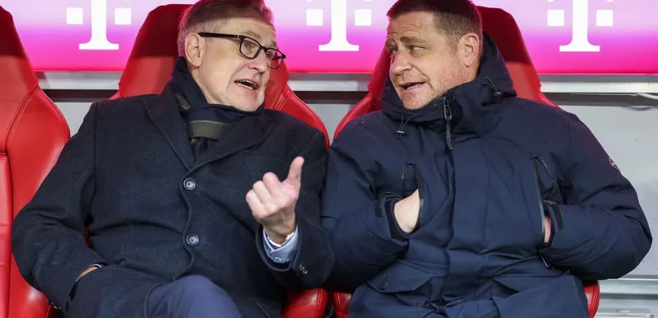 Two individuals talking on the bench during match