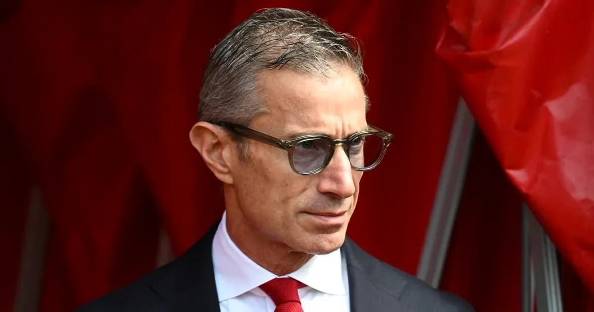 Man in glasses standing near red backdrop