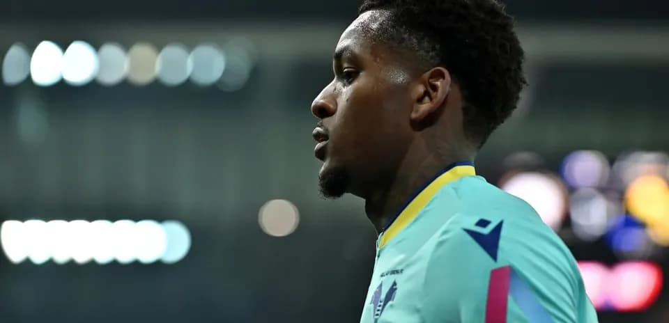 Player in teal kit during match, profile view