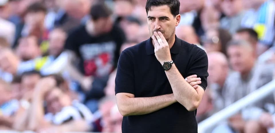 Coach observing match with arms crossed in crowd