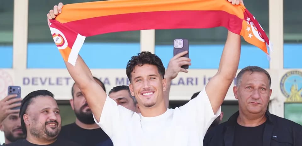 Player holding Galatasaray scarf during announcement event