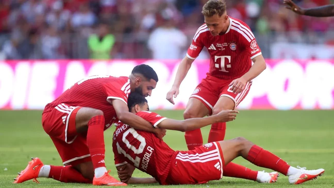 Bayern Munich players assisting teammate on field